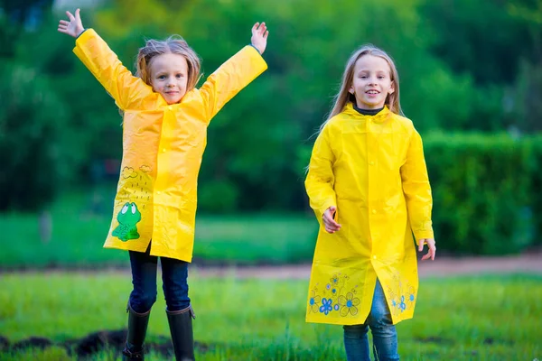 Adorable little girls wearing waterproof coat have fun outdoors — Stock Photo, Image