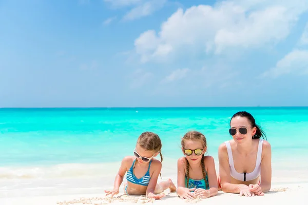 Retrato de la joven y hermosa madre y sus adorables hijas en la playa tropical — Foto de Stock