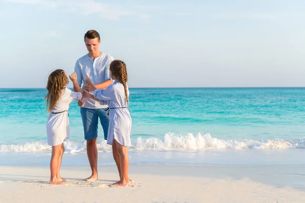 Gelukkig vader en zijn schattige kleine dochters op het strand — Stockfoto