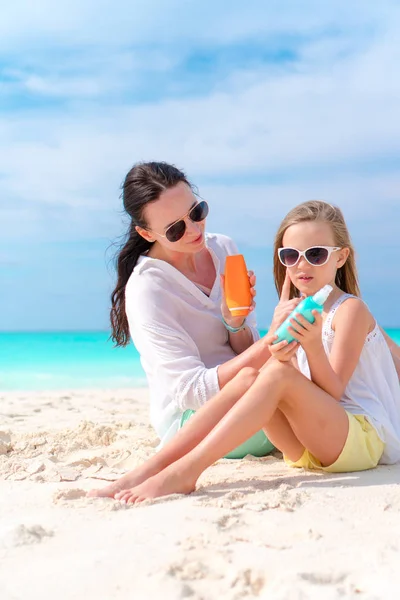 Mamá aplicando crema solar a la nariz de los niños en la playa. El concepto de protección contra la radiación ultravioleta — Foto de Stock