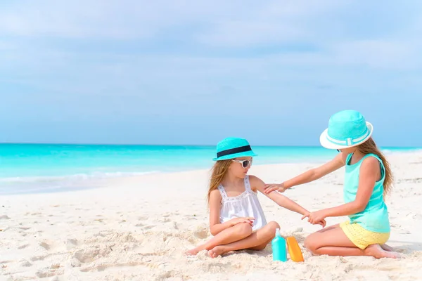 Lapset levittävät aurinkovoidetta toisilleen rannalla. Käsite suojaa ultraviolettisäteilyltä — kuvapankkivalokuva