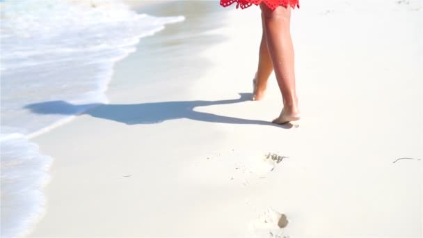 女性の足は浅い水の中の白いビーチに沿って実行しています。ビーチでの休暇と裸足の概念。スローモーション. — ストック動画