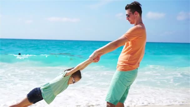 Menina e jovem pai se divertindo durante as férias na praia tropical. LOW MOTION — Vídeo de Stock