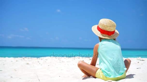 Маленька дівчинка в капелюсі на пляжі під час карибських канікул — стокове відео