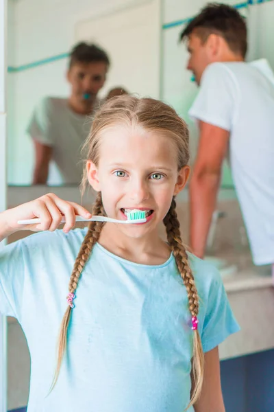 Szczęśliwa dziewczyna i tata szczotkowanie zębów w łazience szczoteczki do zębów — Zdjęcie stockowe