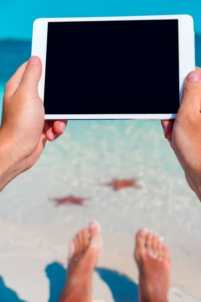 Zbliżenie laptopa w męskie ręce na tle turkus oceanu na tropikalnej plaży — Zdjęcie stockowe