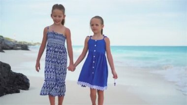 İki küçük kız deniz tarafından beyaz Sahilde yürüyüş