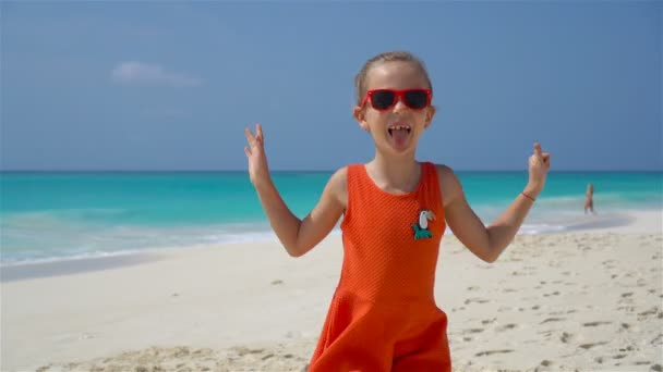 Портрет очаровательной маленькой девочки на пляже во время летних каникул — стоковое видео