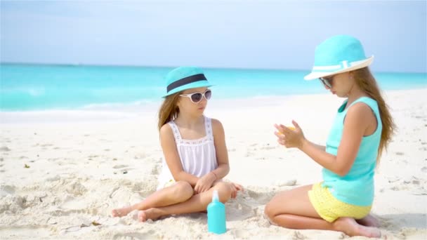 Crianças aplicando protetor solar umas às outras na praia. O conceito de proteção contra radiação ultravioleta — Vídeo de Stock