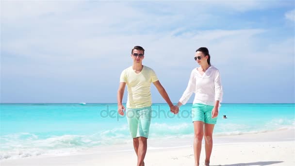 Молодая пара на белом пляже во время летних каникул. Счастливая семья наслаждается своим медовым месяцем. Медленное движение ВИДЕО . — стоковое видео