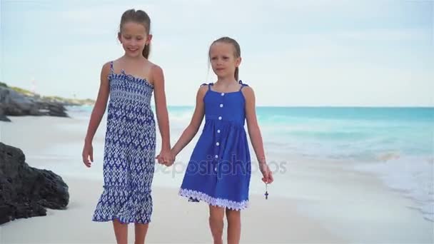 Twee zusjes lopen door de zee op het witte strand — Stockvideo