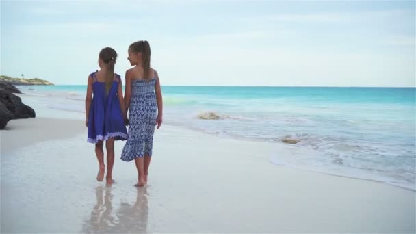 Niñas caminando por el mar en la playa blanca. Niños de vacaciones en la playa por la noche — Vídeos de Stock