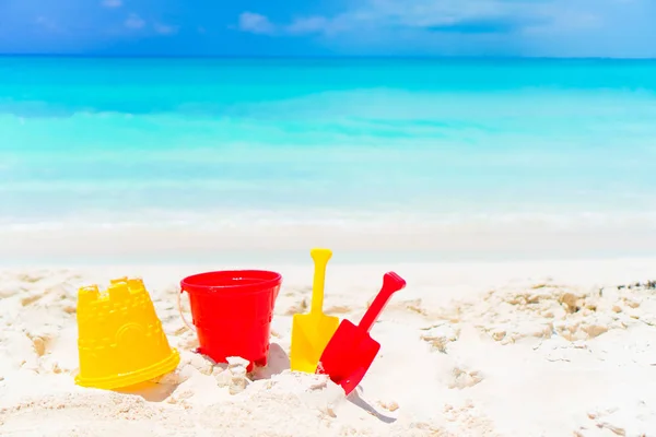 Juguetes de playa para niños sobre fondo de playa de arena blanca el mar — Foto de Stock