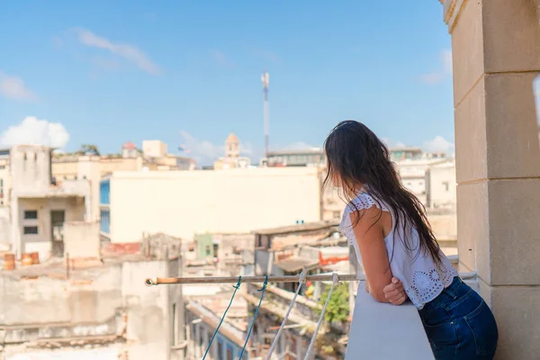 Jonge aantrekkelijke vrouw op oude balkon in appartement in Havana met vie van de oude stad en huizen — Stockfoto