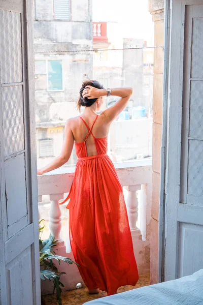 Young beautiful woman in red dress on old balcony in apartment in Old Havana, Cuba. — Stock Photo, Image