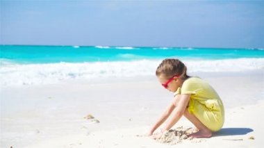 Kumsalda kumla oynayan sevimli küçük kız.