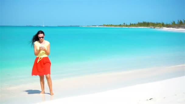 Mladá žena používá telefon během dovolené na tropické pláži. Turistika pomocí mobilního telefonu. — Stock video
