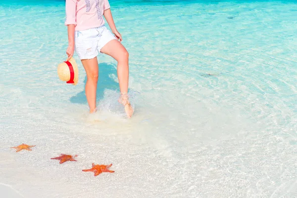 Frauenfüße am weißen Sandstrand. Seestern am weißen Sandstrand im flachen Wasser — Stockfoto