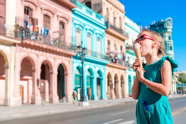 Söt liten flicka som äter glass i populärt område i Old Havana, Kuba. Porträtt av den sötaste ungen utomhus på en gata i Havanna — Stockfoto