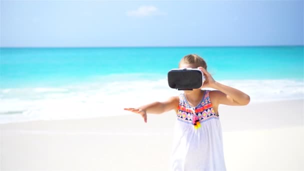 Schattig meisje met behulp van Vr virtual reality bril op het witte strand. — Stockvideo