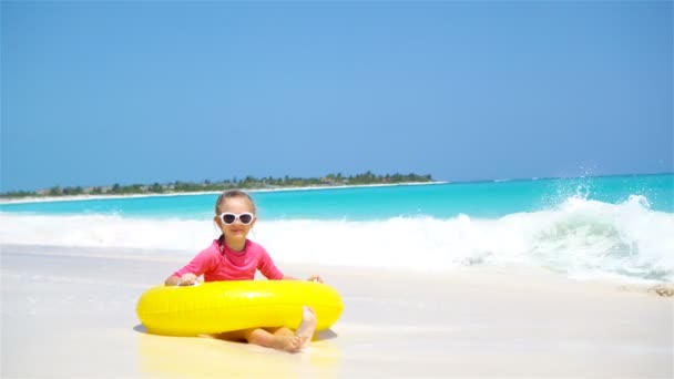 Adorable niña con círculo de goma inflable salpicaduras. Niño divirtiéndose en vacaciones activas de verano — Vídeos de Stock