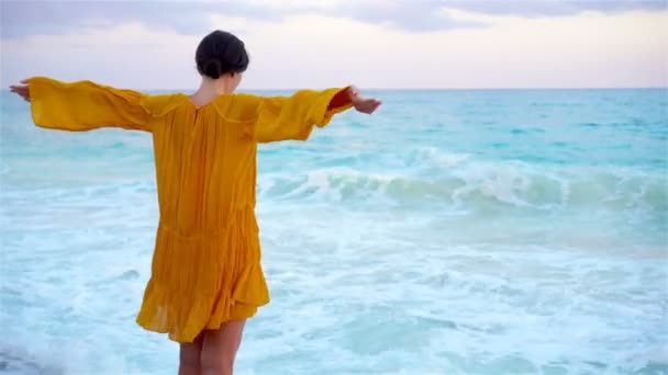 Günbatımı genç güzel kadın. Mutlu kız sahilde akşam elbiseli — Stok video