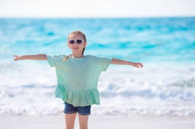 Mutlu küçük kız Karayipler tatil sırasında kumsalda yürüyüş