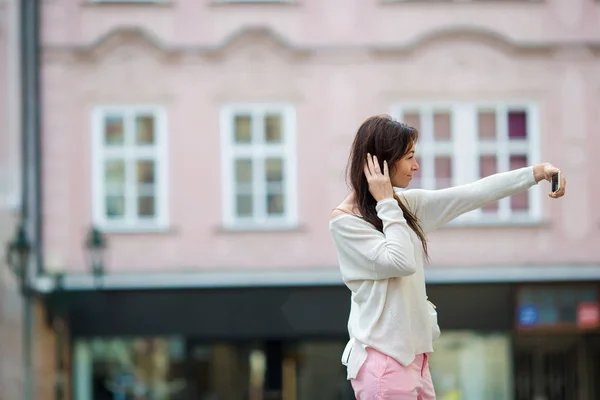 Young caucasian woman taking self portrait in european city — Stock Photo, Image