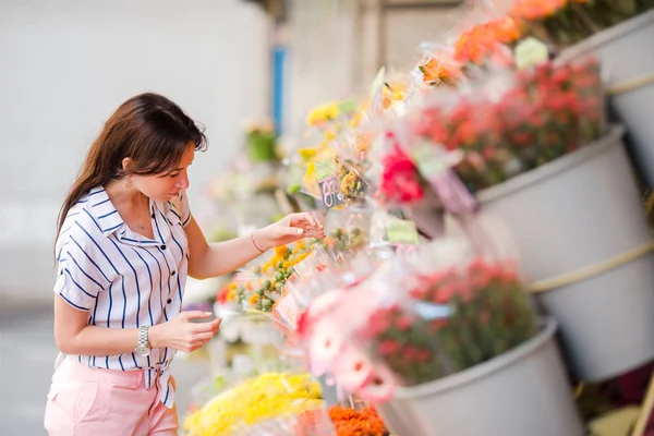 Schöne junge Frau beim Aussuchen frischer Blumen auf dem europäischen Markt — Stockfoto