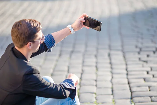 Close up de mãos masculinas está segurando celular ao ar livre na rua. Homem usando smartphone móvel . — Fotografia de Stock