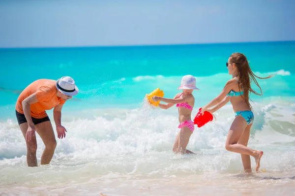 Małe dziewczynki i szczęśliwy tata zabawy podczas wakacji na plaży — Zdjęcie stockowe