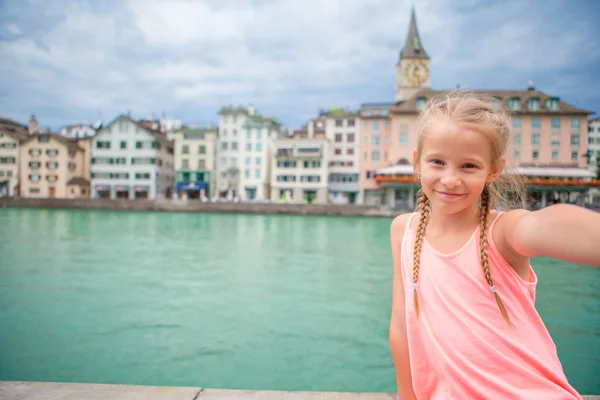 Menina adorável tirando selfie ao ar livre em Zurique, Suíça. Retrato de close-up de fundo de criança da bela cidade — Fotografia de Stock