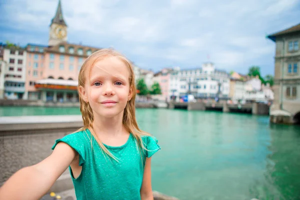Rozkošná holčička s selfie venku v Curychu, Švýcarsko. Detailní portrét kid pozadí krásného města — Stock fotografie