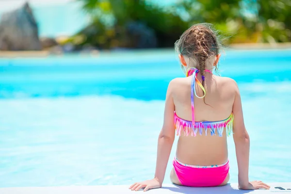 Adorable little girl on the edge of outdoor swimming pool — Stock Photo, Image