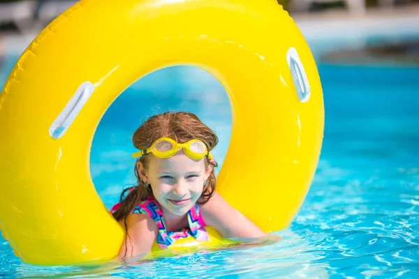 Meisje met opblaasbare rubberen cirkel plezier in zwembad buiten — Stockfoto
