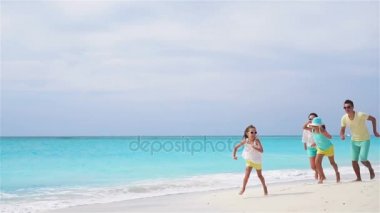 Genç aile tatilde plajda eğlenceli bir sürü var. Ağır çekim.