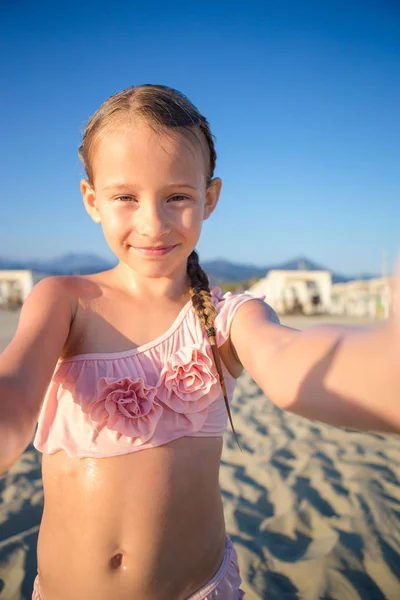 Glückliches kleines Mädchen macht Selfie am europäischen Strand während der Sommerferien in Italien — Stockfoto