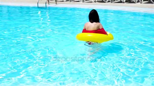 Krásná mladá žena odpočívající v bazénu. Šťastná dívka ve venkovním bazénu v luxusním hotelu. Zpomalený pohyb — Stock video