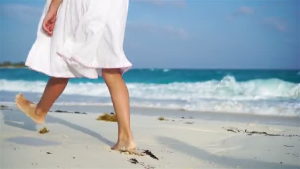 Close-up kinderbenen lopen langs het witte strand. Begrip strandvakantie en blootsvoets. — Stockvideo