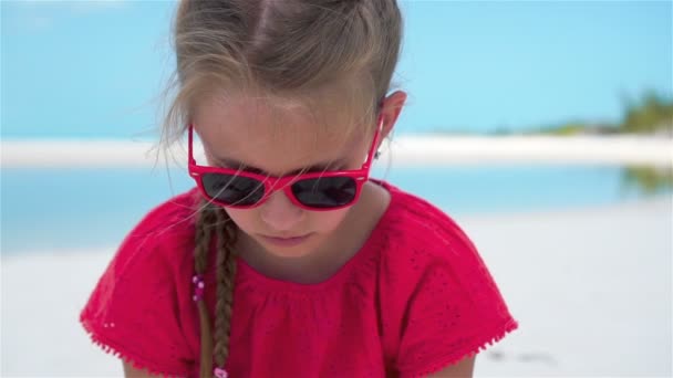 SLOW MOTION ZAMKNIJ: Dziewczyna bawiąca się pięknym białym piaskiem na egzotycznej plaży — Wideo stockowe