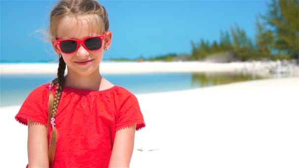 Портрет очаровательной маленькой девочки на пляже во время летних каникул — стоковое видео