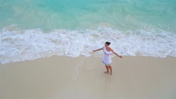 Joven mujer hermosa en la orilla del mar tropical. Vista superior de la chica feliz en hermoso vestido en la playa blanca — Vídeo de stock