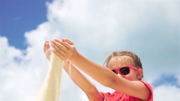 Mała dziewczynka bawiąca się pięknym białym piaskiem na tropikalnej plaży. SŁUGA MOTION — Wideo stockowe