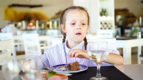 Adorable petite fille prenant le petit déjeuner au café extérieur — Video