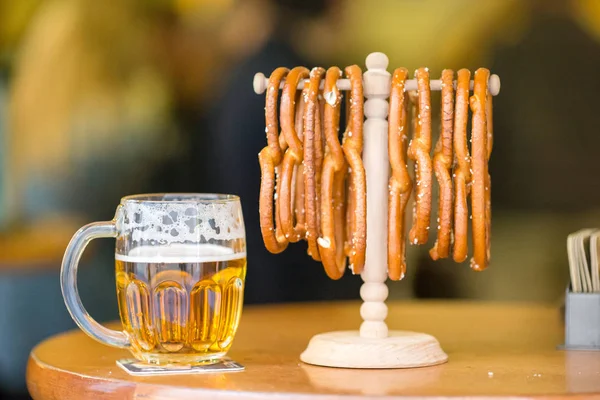 Close-up van gezouten soft pretzels en bier op houten achtergrond. — Stockfoto