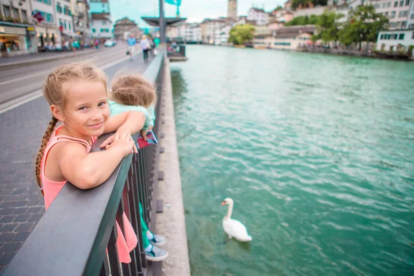 Rozkošné holčičky venku v Curychu, Švýcarsko. Děti v krásném městě poblíž řeky a labutě — Stock fotografie