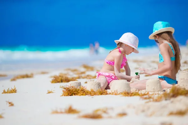 Meninas pequenas felizes brincando com brinquedos de praia durante as férias tropicais — Fotografia de Stock