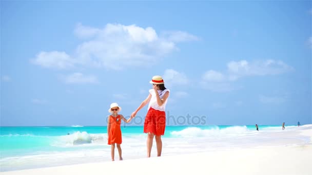 Tropikal sahilde küçük tatlı bir kız ve genç bir anne. — Stok video