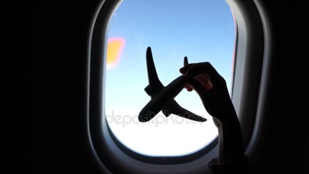 Closeup χέρι κρατά ένα αεροπλάνο μοντέλο παιχνίδι φόντο παράθυρο στο αεροσκάφος — Αρχείο Βίντεο