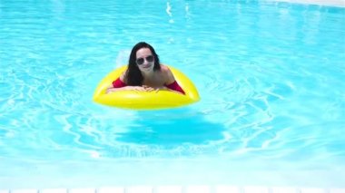 Mutlu kız havuzda eğleniyor. Güzel kadın lüks otelde açık yüzme havuzunda. Ağır çekim